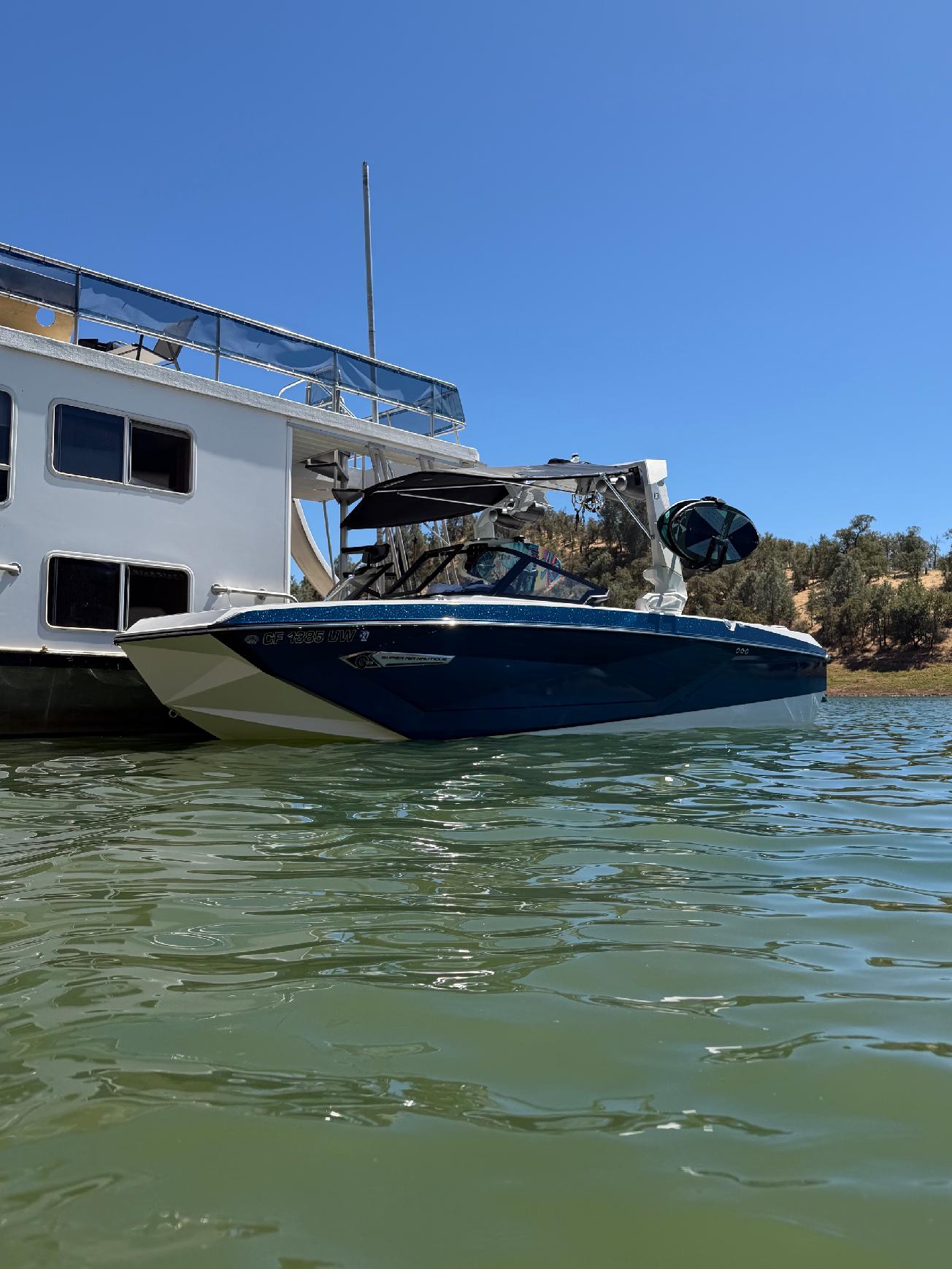 Premier Wake Co Nautique G23 beside a houseboat